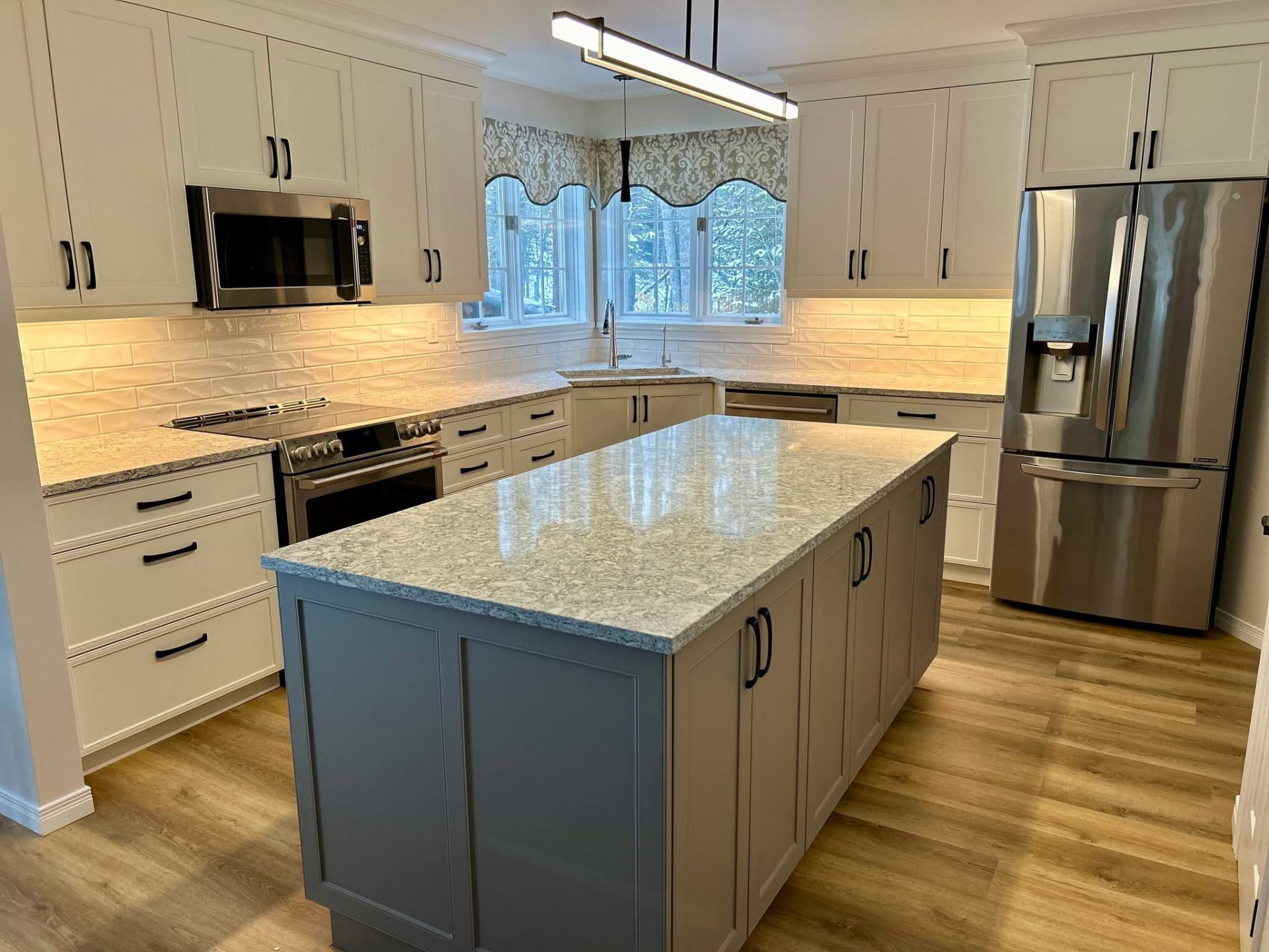 Bright custom kitchen with white shaker cabinets and statement island