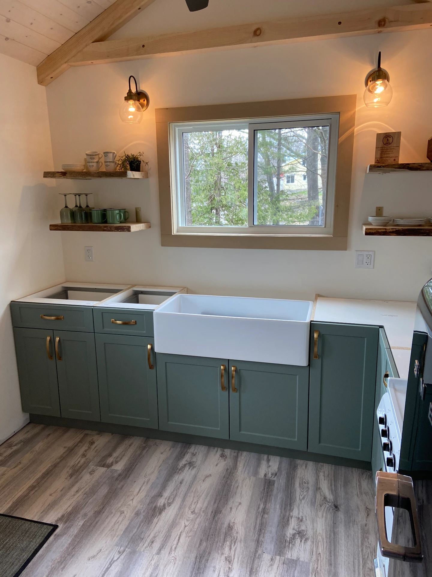 Sage green custom cabinets with farmhouse sink and brass hardware